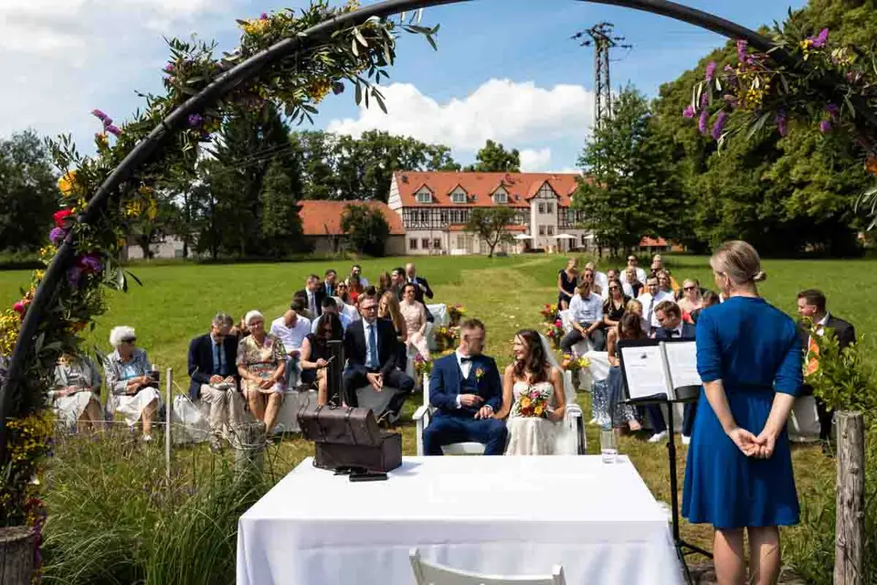 Freie Trauung auf der Wiese, Blick durch den Blumenbogen zum Weiherhof