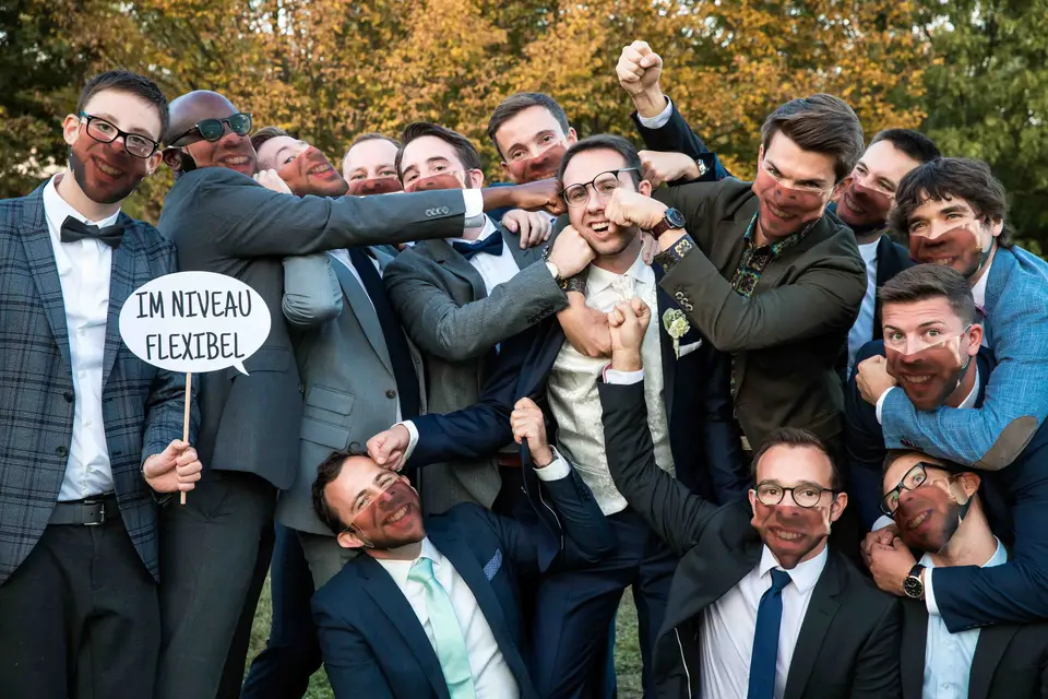 Bräutigam und seine Freunde posieren ausgelassen für ein lustiges Gruppenbild