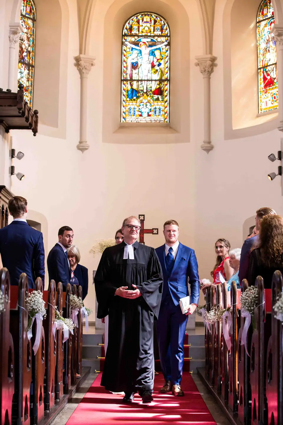 Brautpaar zieht mit dem Pfarrer aus der Kirche aus