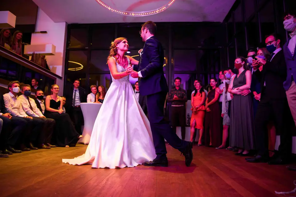 Brautpaar beim Hochzeitstanz im Saal, Gäste schauen zu
