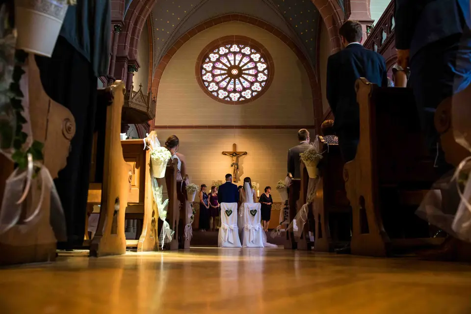 Trauung in der Kirche, Blick vom Boden durch die Bankreihen