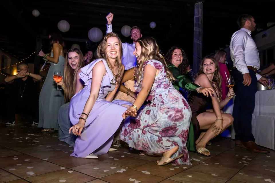 Gäste tanzen ausgelassen in der Hocke auf der Tanzfläche