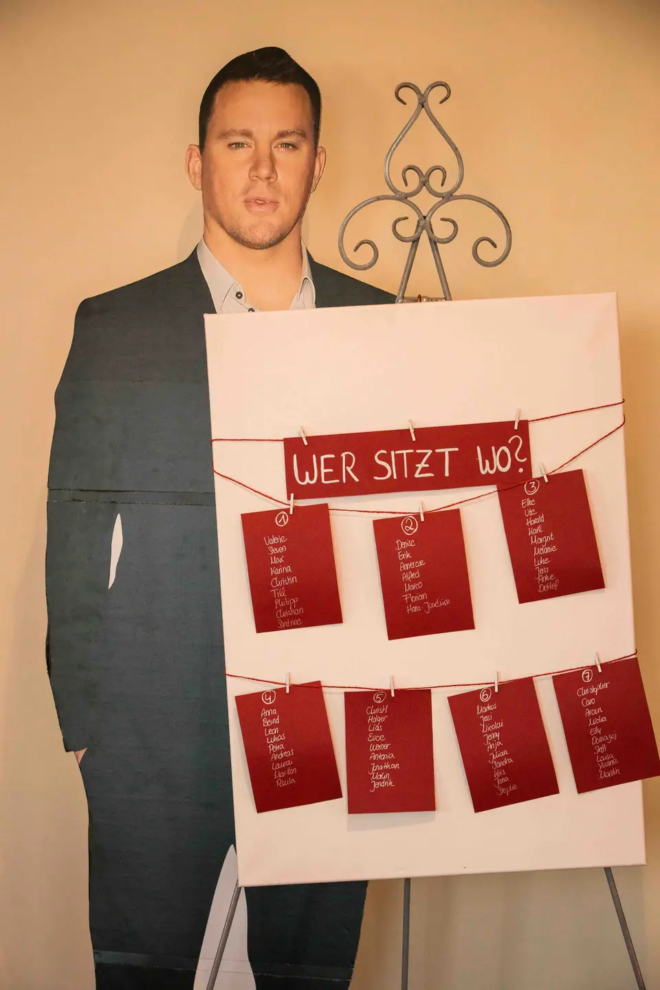 Tischplan mit roten Karten neben einem lebensgroßen Pappaufsteller