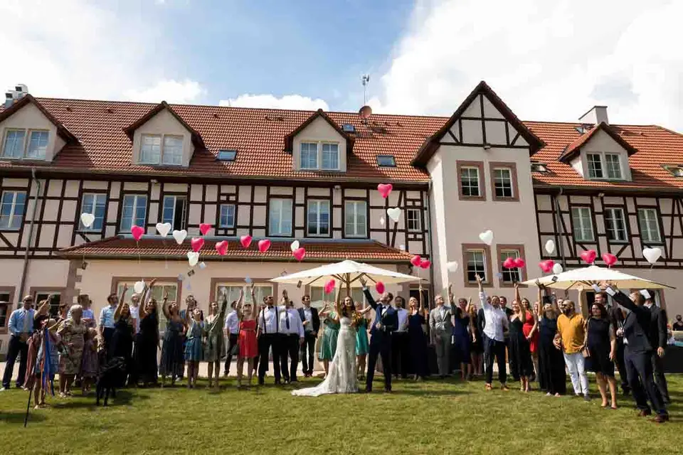 Gruppenfoto der Hochzeitsgesellschaft vor dem Fachwerkhaus des Weiherhofs