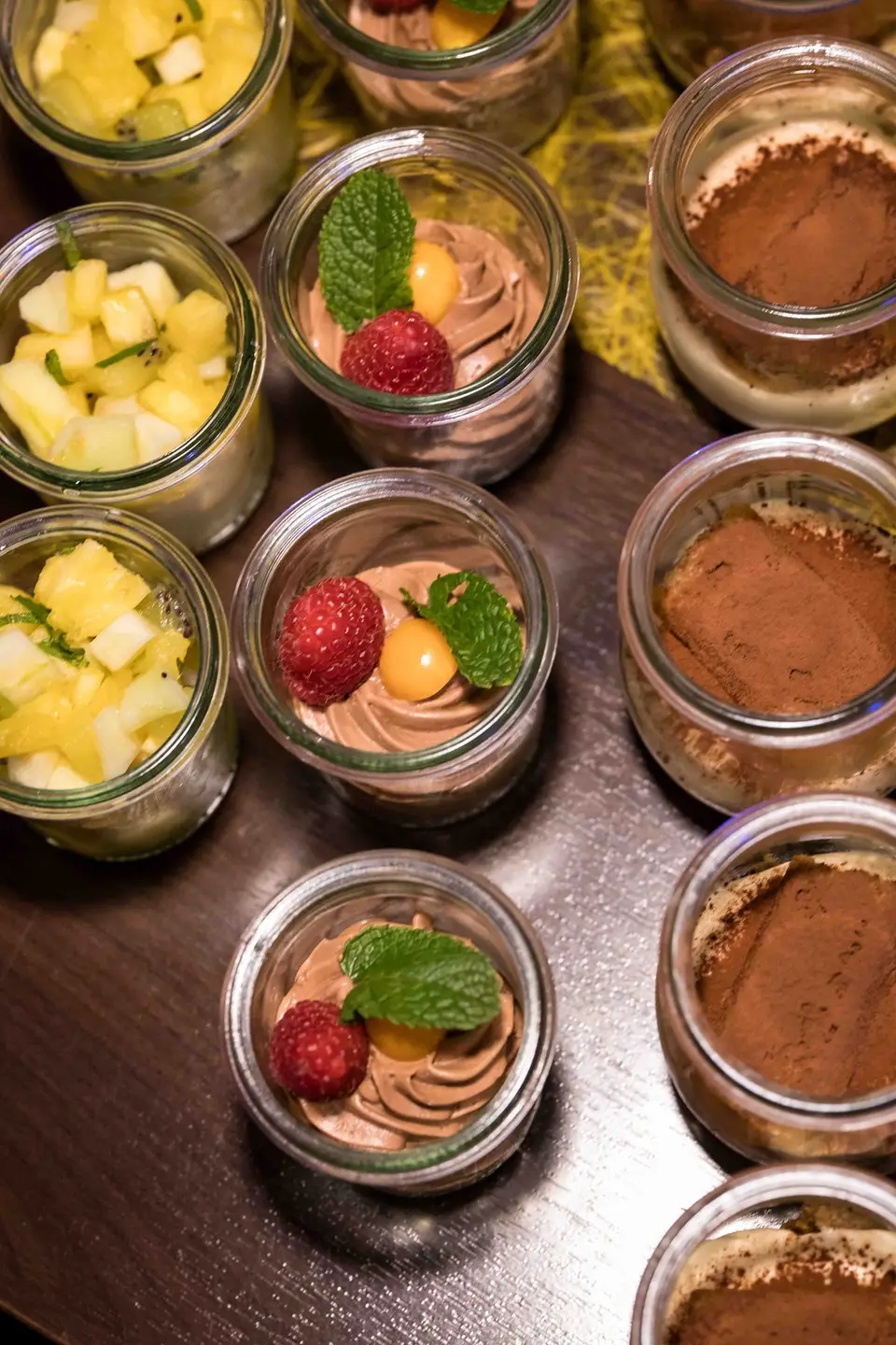 Dessert in kleinen Gläsern mit Mousse, Ananas und Himbeeren