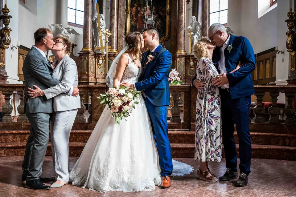 Generationskuss: Brautpaar und zwei Paare küssen sich vor dem Altar