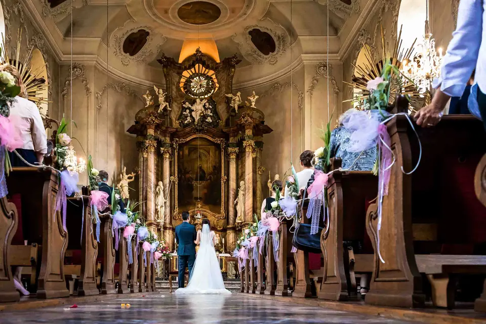 Blick durch den geschmückten Mittelgang zum Brautpaar am Barockaltar