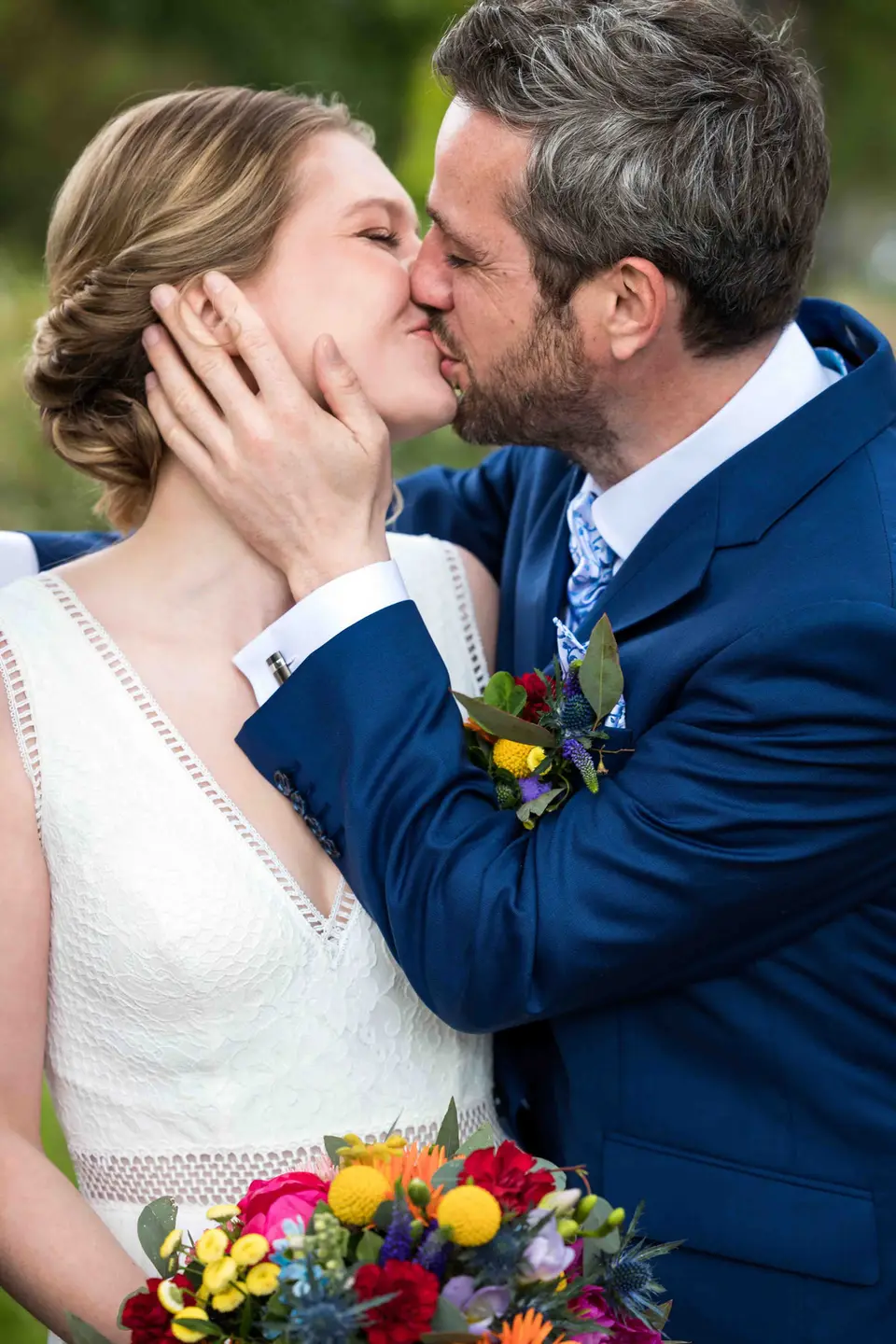 Hochzeitskuss, Braut hält das Gesicht des Bräutigams