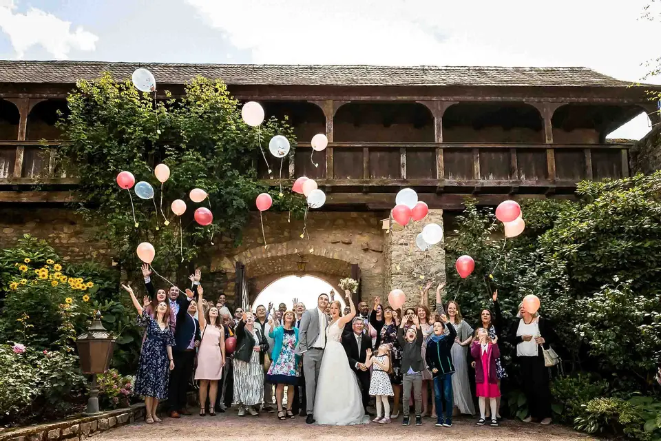 Hochzeitsgesellschaft lässt Luftballons im Rosengarten der Burg Eltville steigen