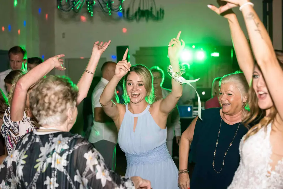Gäste tanzen ausgelassen unter grünem Partylicht