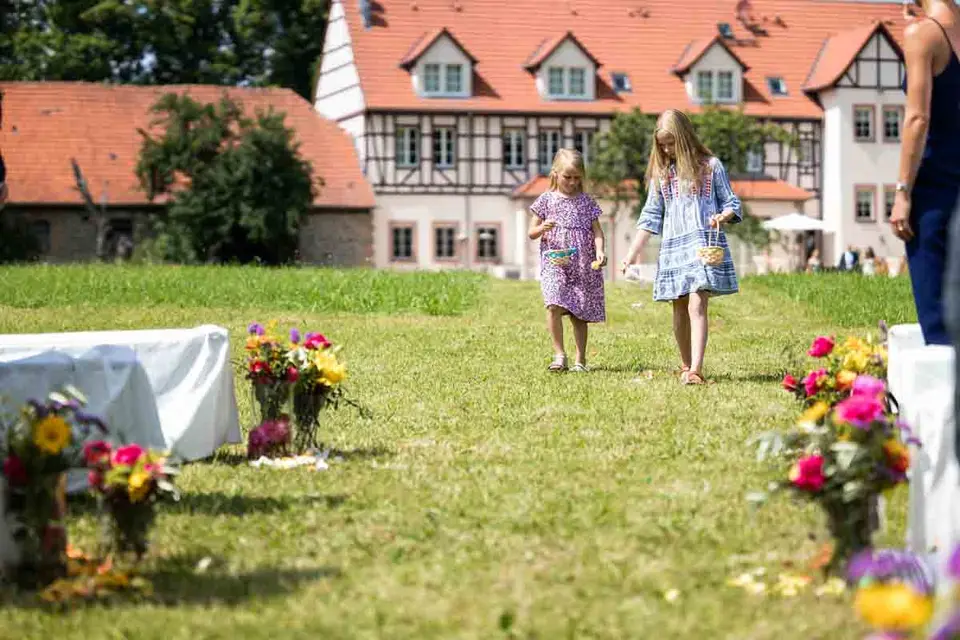 Blumenmädchen auf dem Weg zur freien Trauung über die Wiese