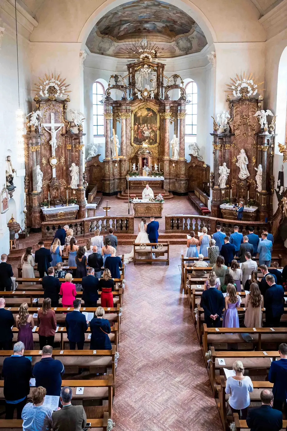 Blick von der Empore auf Kirchenschiff, Gäste und Altar während der Trauung