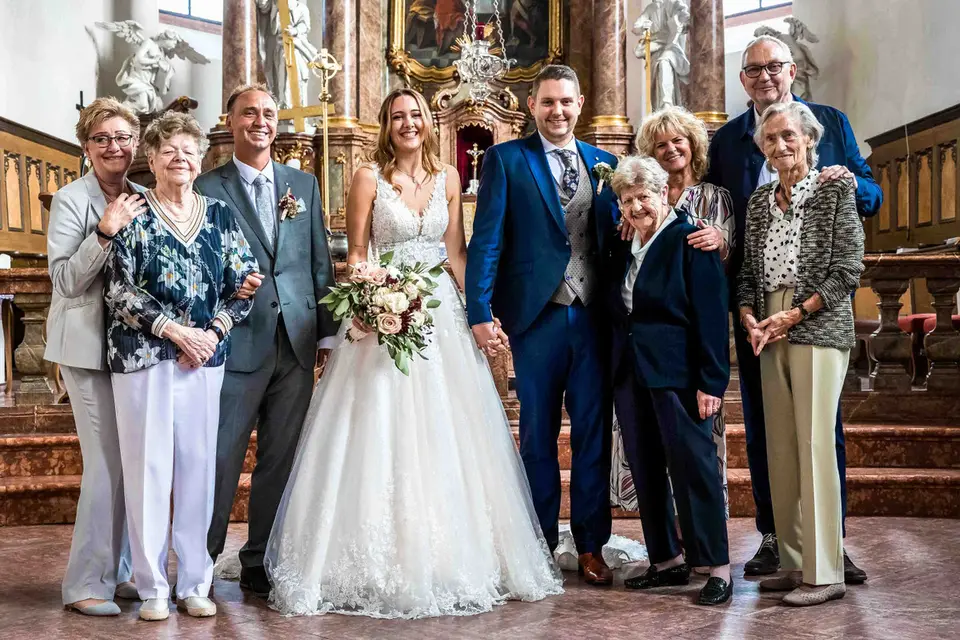 Familienbild mit Brautpaar und Angehörigen im Altarraum der Kirche