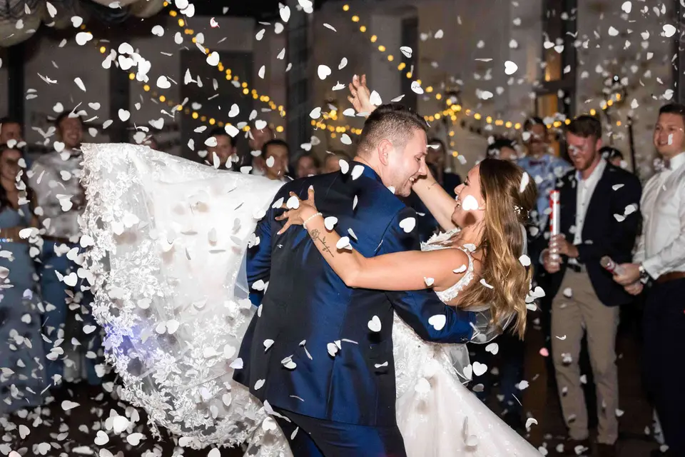 Hochzeitstanz des Brautpaars im Regen aus weißen Papierherzen