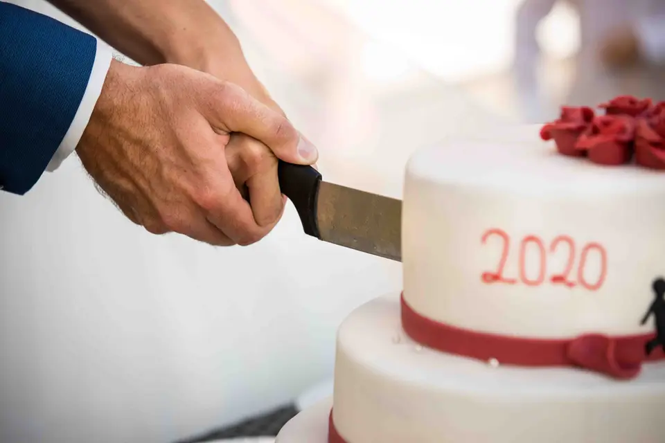 Bräutigam schneidet die Hochzeitstorte an