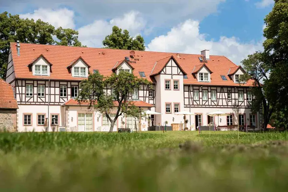 Fachwerkgebäude des Weiherhofs Wächtersbach hinter einer grünen Wiese