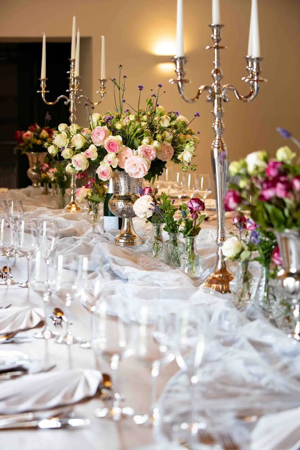 Hochzeitstafel mit Kerzenleuchtern, Blumen und Gläsern