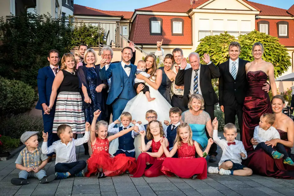 Großes Familienbild mit Brautpaar und Kindern vor dem Hofgut