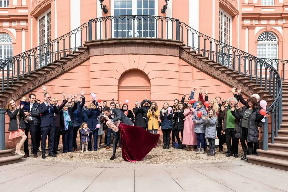 Gruppenbild vor der Freitreppe von Schloss Biebrich, Brautpaar im Kuss