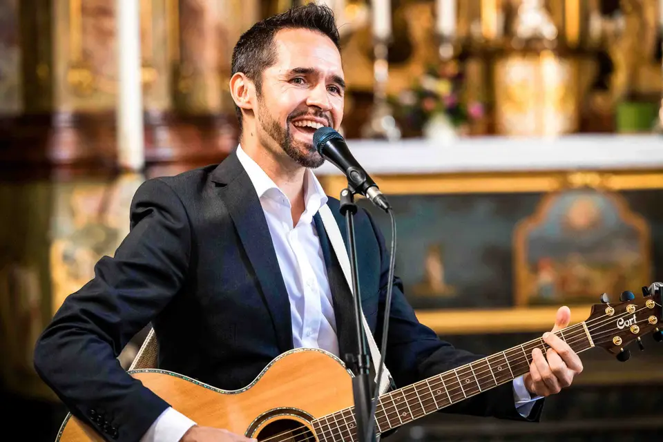 Sänger mit Gitarre singt während der Trauung in der Kirche