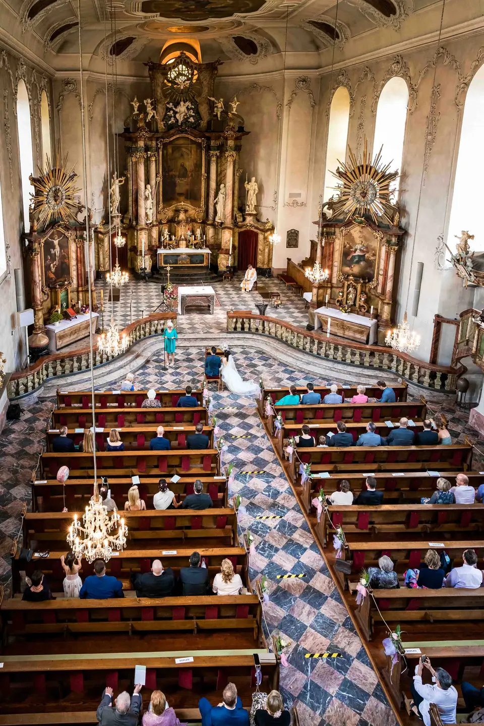 Blick von oben auf Kirchenschiff, Gäste und Altar von St. Gallus