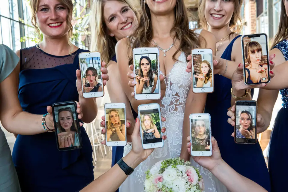 Brautjungfern zeigen Handys mit Gesichtern rund um die Braut