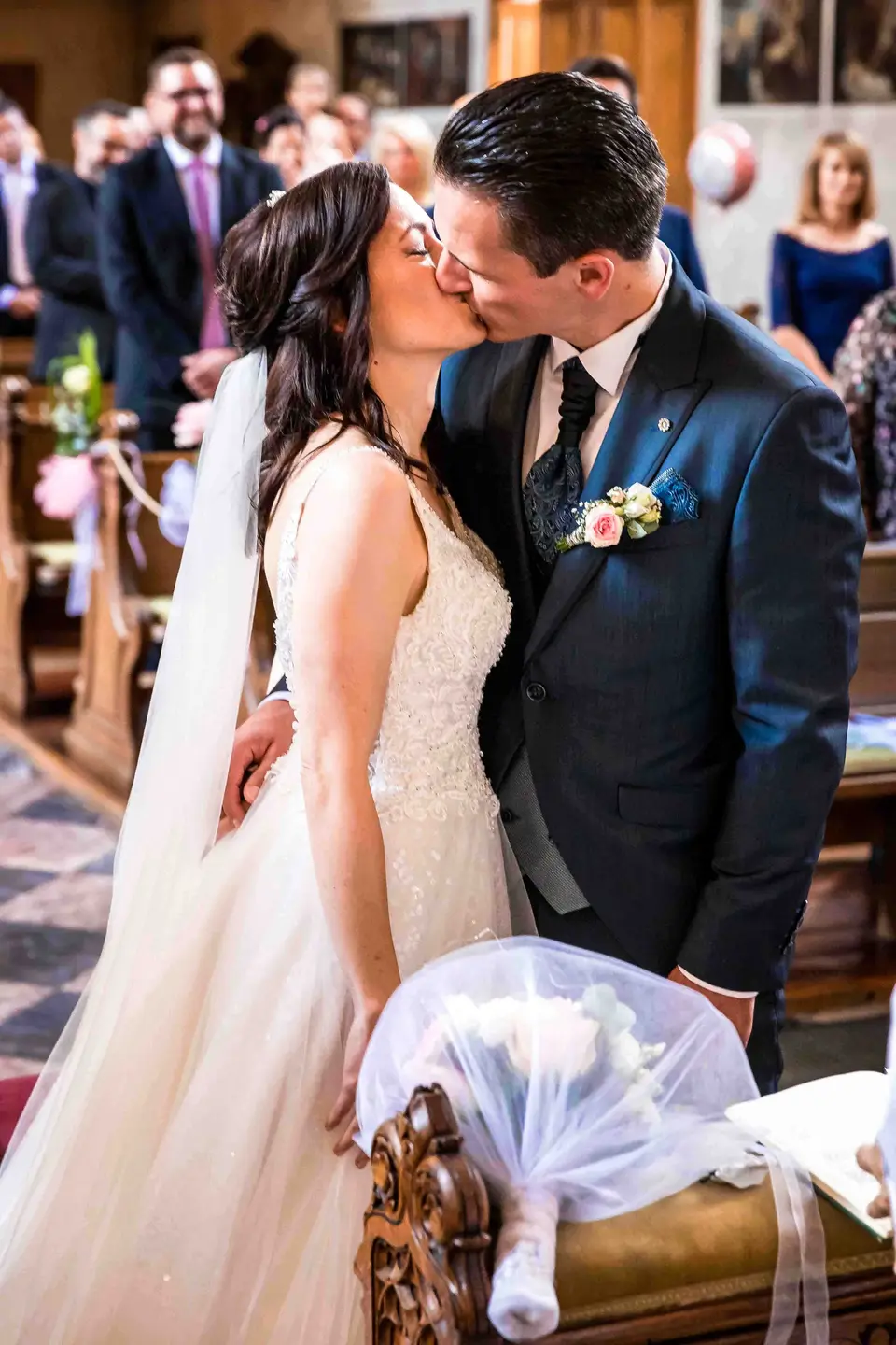Hochzeitskuss des Brautpaars in der Kirchenbank