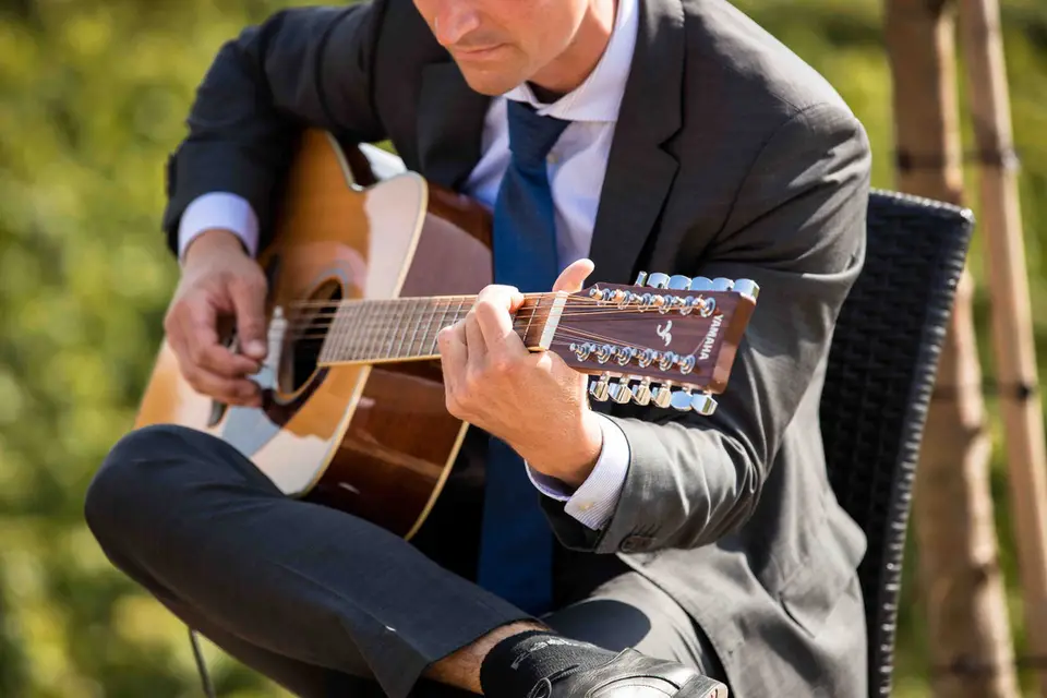 Nahaufnahme des Gitarristen beim Spiel auf der zwölfsaitigen Gitarre