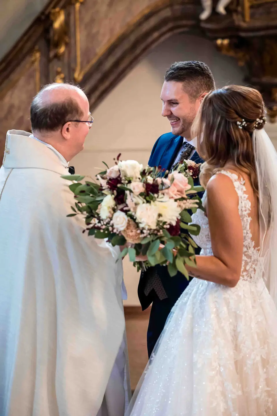 Pfarrer überreicht dem Brautpaar nach der Trauung ein Geschenk der Kirche